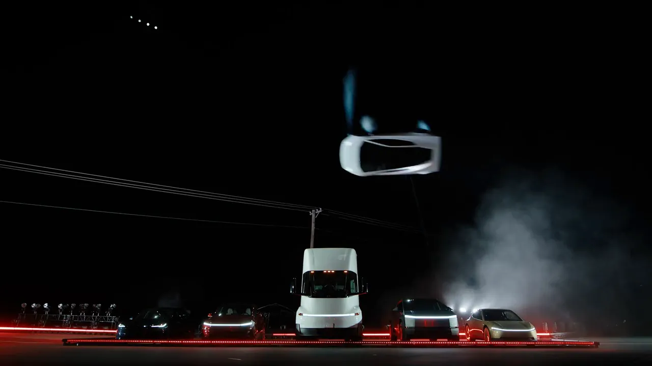 The Roadster flipping high above a line of Tesla vehicles including the Semi
